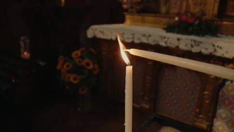 Person lighting a candle inside historic church, creating warm flame Stock Footage 342113629