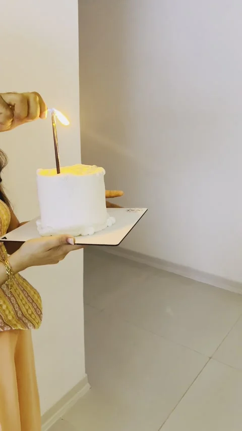 Person lighting a candle on a small white birthday cake Stock Footage 345146876