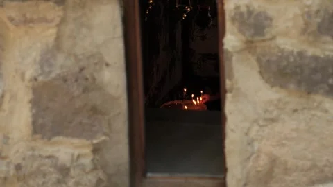 Person lighting the candle, visible through an old church windows from otside Vidéo 288380649