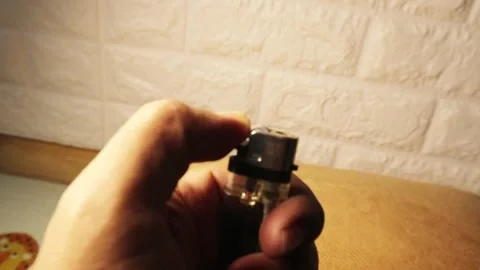 A person lighting a lighter, producing a bright flame Stock Footage 303200554