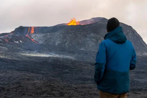 Person looking at an Active Volcano with exploding red Lava in Iceland Foto stock