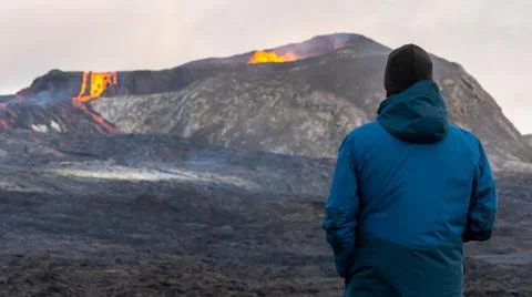 Person looking at an Active Volcano with exploding red Lava in Iceland Foto stock