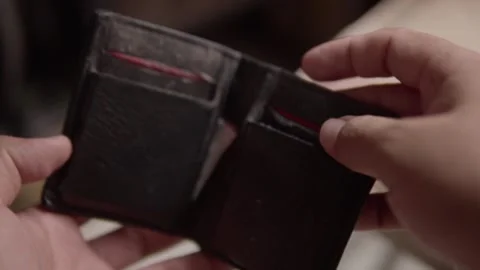 Person Looking Into Empty Wallet Illustrating Financial Difficulty and Money Stock Footage 337972110