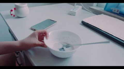 Person Looking at Phone After Putting Cereal Bowl Down Stock Footage 341532811