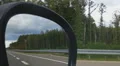 Person looking at road in side view mirror. Driving car on interstate highway HD Footage