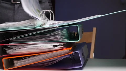Person looking through stack of overflowing office binders Stock Footage 322912720
