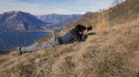 Person lying photographing mountain birds Stock Footage 59721086