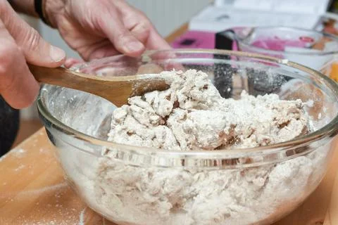 Person making bread in home kitchen adding ingredients to make the dough Stock Photos