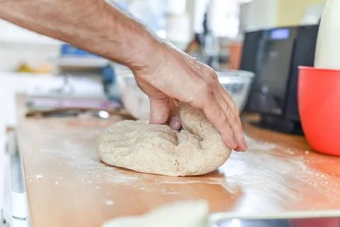 Person making bread in a home kitchen adding ingredients to make the dough an Stock Photos