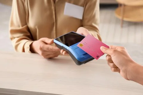Person making contactless payment with credit card and terminal Stock Photos