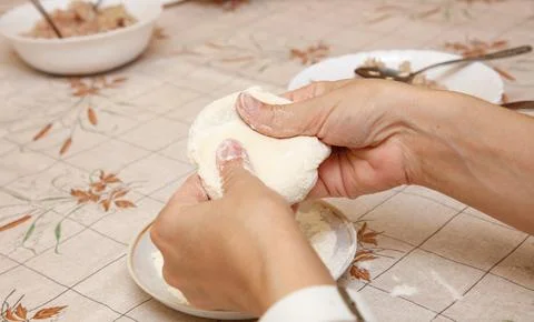 A person is making a dough on a table Stock Photos