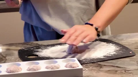 A person is making doughnuts in a kitchen 스톡 동영상 275326250
