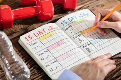 Person Making Exercise Plan On Notebook Foto stock