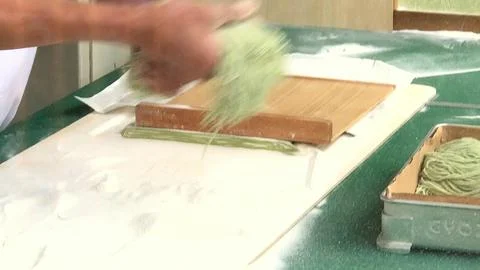 Person making pasta by hand in kitchen with flour and dough Stock Photos