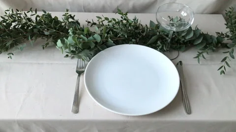 Person making a table setting with green garland. Simple place setting. Stock Footage 168331649