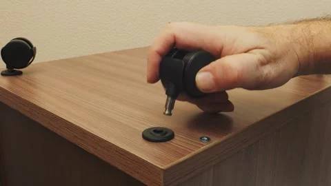 A person manually screws in screws while assembling a room furniture set wi.. 库存影片 330128337