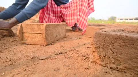 A person manually shaping bricks in an open field. Vídeos de archivo 333051113