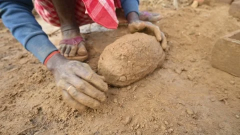 A person manually shaping bricks in an open field. Vídeos de archivo 333051115