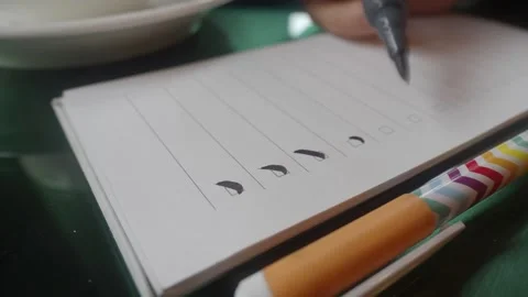 Person marking completed items on white checklist with black marker in cine.. Stock Footage 332579579