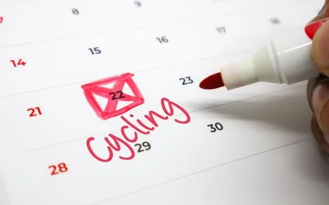 Person marking Cycling on calendar with red marker. Concept of fitness plan.. Stock Photos