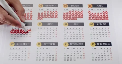 Person Marking Dates on a Calendar with Red Pen for Important Event Stock Footage 323994300