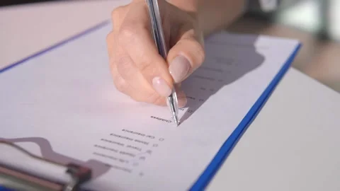 The person marks the correct answer in the test with a tick Stock Footage 145628989