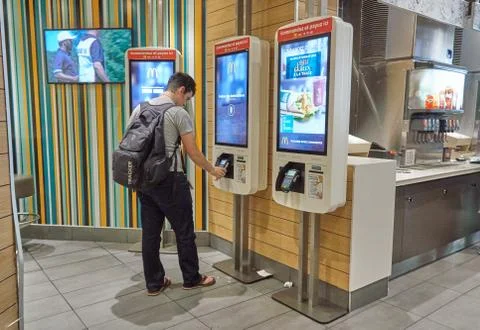 A person in McDonalds at automatic machine. Фото