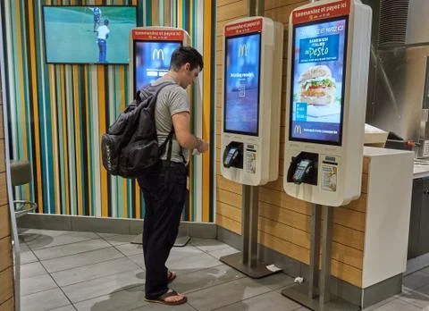A person in McDonalds at automatic machine. Stock Photos
