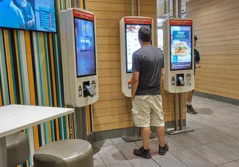A person in McDonalds at automatic machine. Фото