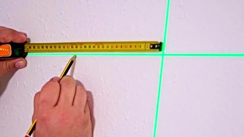 Person measuring and marking on the wall with the help of a laser pointer. Stock Footage 306674508