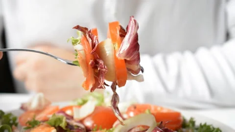 Person mixes salad elements with silver fork Stock Footage 130335266