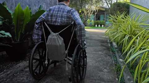 A person with mobility challenges rolls through the hotel park, highlighting the Stock Footage 264159688