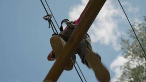 Person navigating a high ropes adventure course in Stockholm, Sweden. 스톡 동영상 330977532