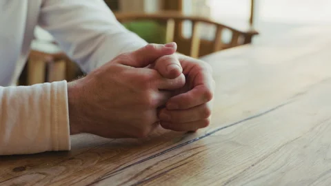 A person nervously cracking fingers while waiting sitting at the table Stock Footage 332837694