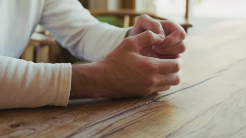 A person nervously cracking fingers while waiting sitting at the table Stock Footage 332838577