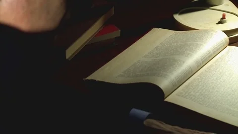 A person at night in the office at the table writes a pencil text on a sheet of Stock Footage 79416534