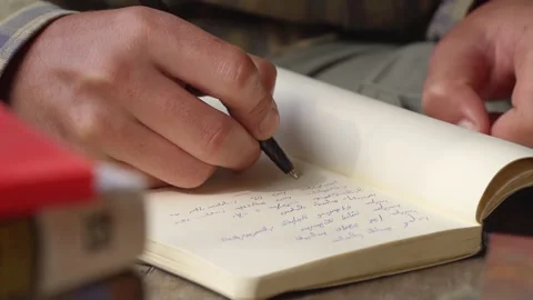 Person note taking in Georgian script writing system, using a pen and a Stock Footage 146742787