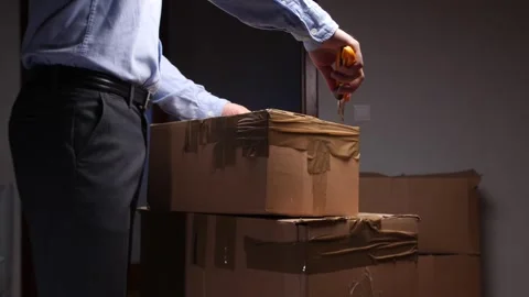 Person opening cardboard box using utility cutter Stock Footage 318983114