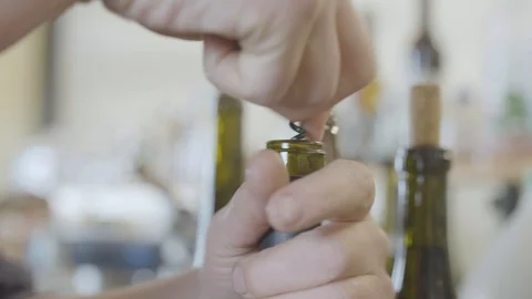 Person opening a wine bottle with a corkscrew Stock Footage 87801336