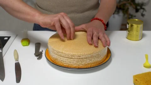 A person opens a can, presumably of condensed milk, while a stack of wafer Stock Footage 336068395