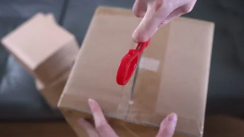 Person opens package. Cutting sealed delivery open with kitchen scissors Stock Footage 151662545