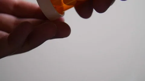 Person Opens Pill Bottle and Pours Pills On To Camera in Slow Motion Stock Footage 92868062