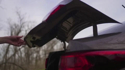 Person opens the trunk of the car, side view 4K 10 BIT Stock Footage 194483304