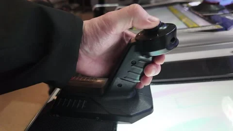 Person operating black joystick controller on illuminated console indoors Stock Footage 343682203