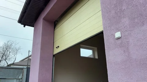 Person is operating a remote control closing a garage door or gate for a car. 库存影片 346721734
