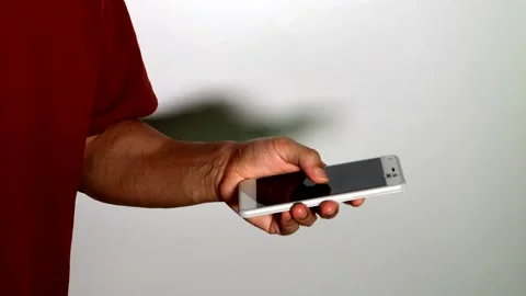 A person operating a smartphone while holding a wad of cash. Video stock 334692144