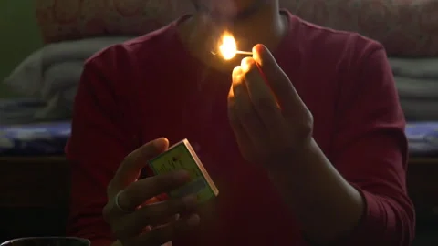 A person or man lighting a matchstick in slow motion Stock Footage 248733862