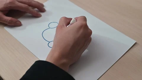 A person outlines circular shapes using a marker on a sheet of paper. This Stockbeeldmateriaal 337550285