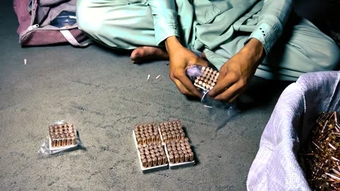 Person Packaging Bullets into Plastic Bags in an Ammunition Factory Stock Footage 336726726