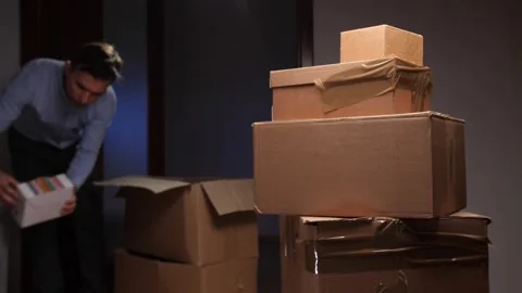 Person packing small items into large moving box Stock Footage 318981525